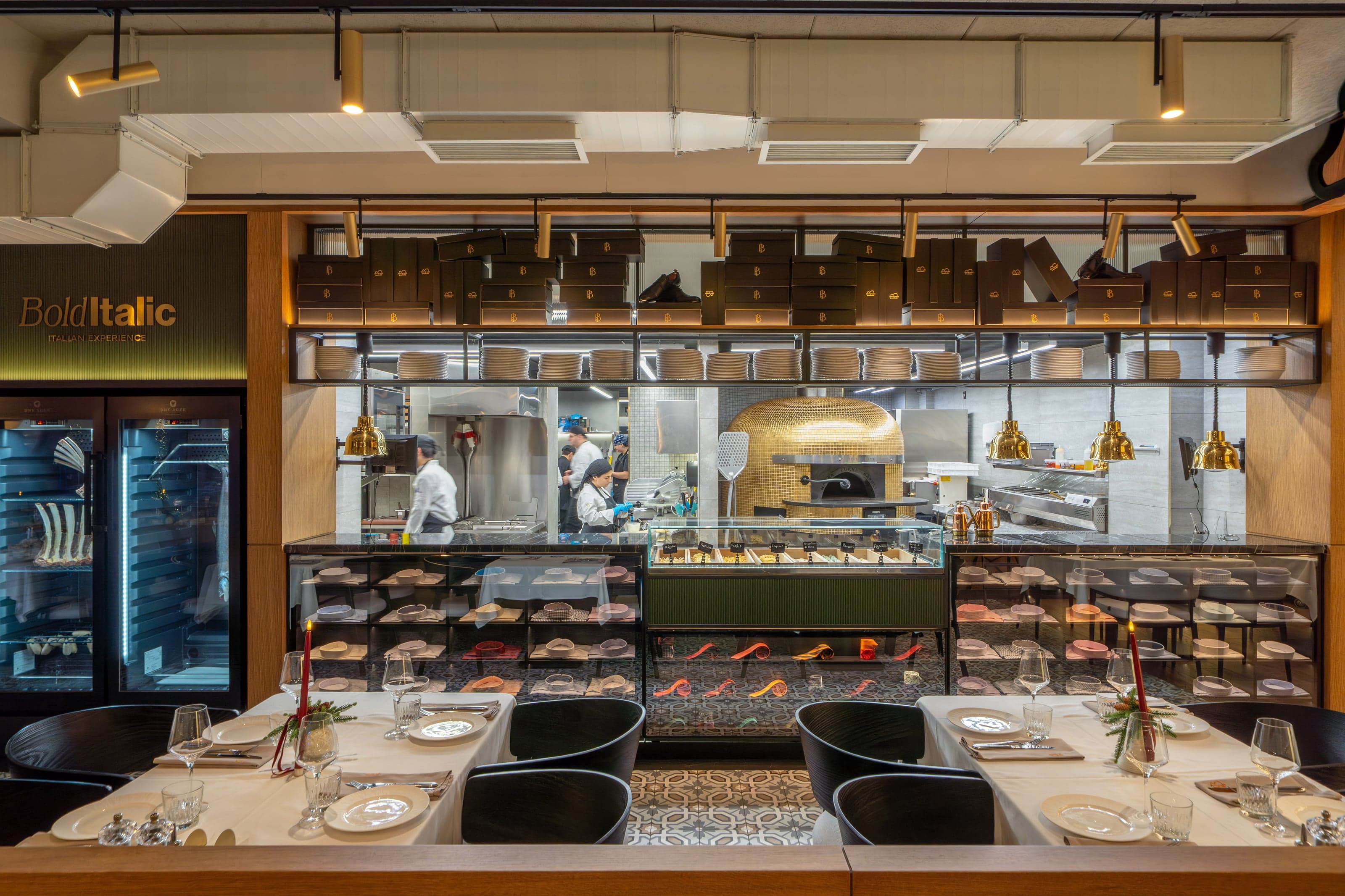 Bold Italic open kitchen and dry-aging display beneath the restaurant's gold signage