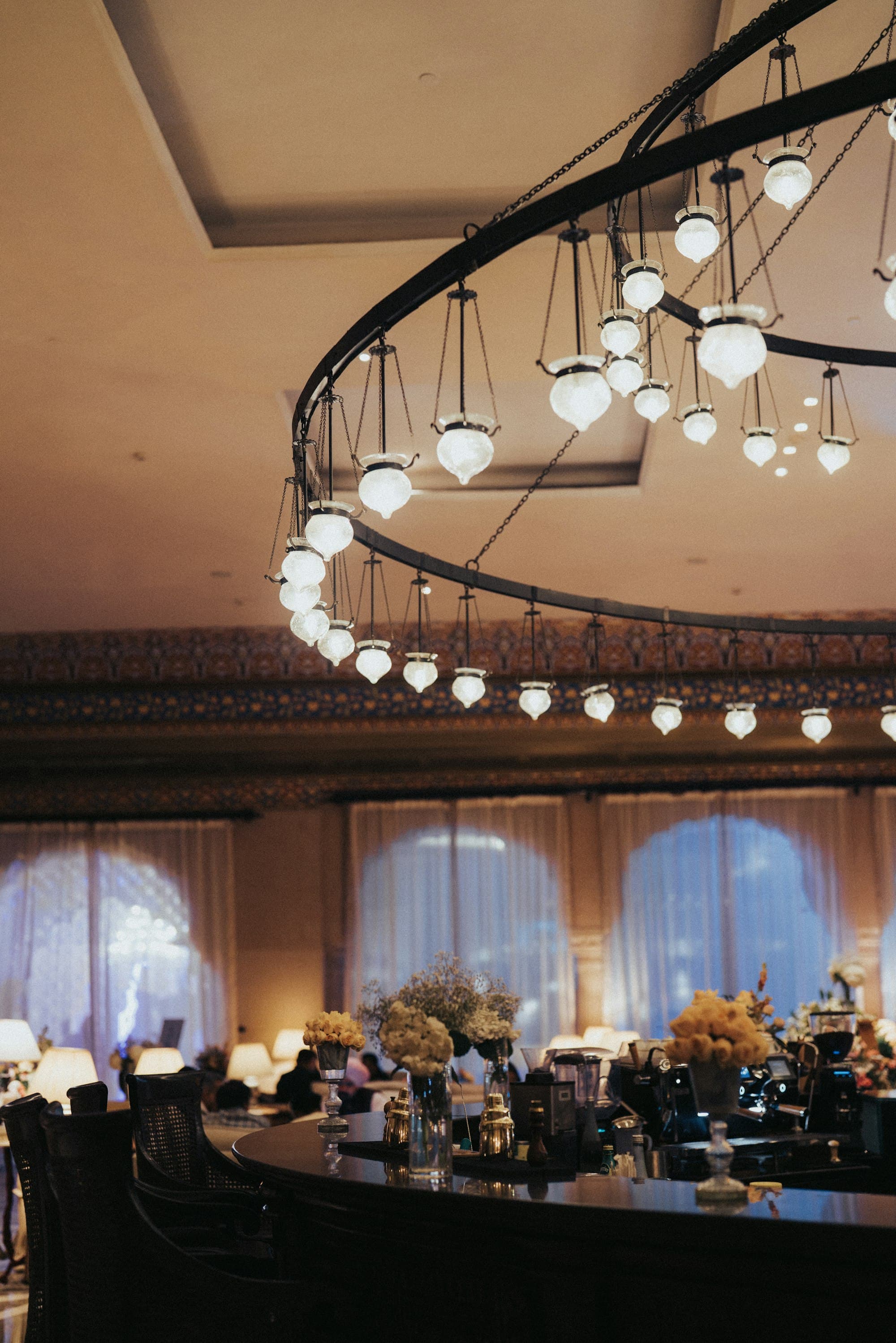 Warm hotel lounge with arched windows and pendant chandelier