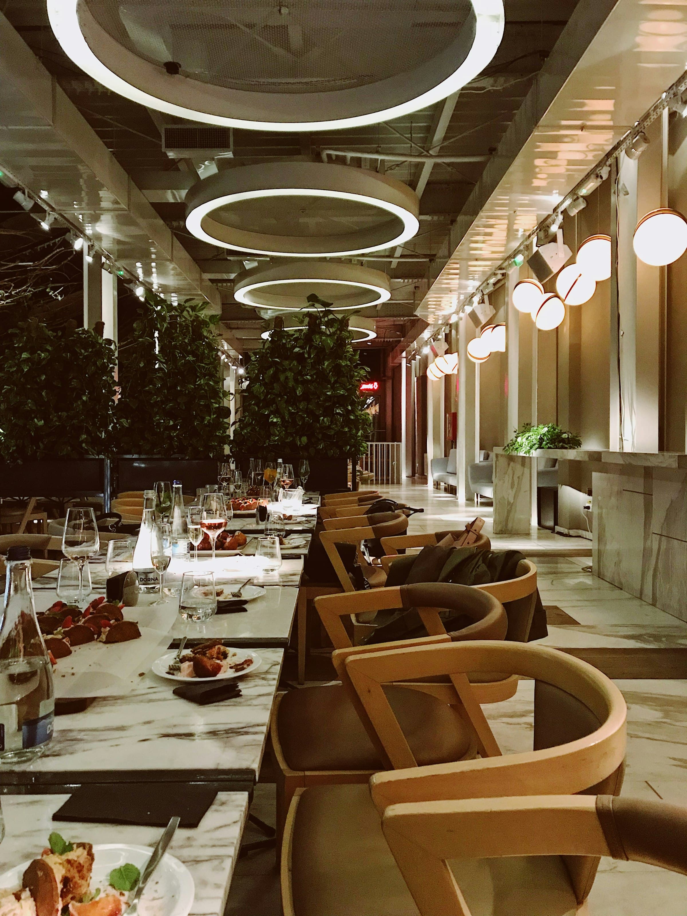 Circular pendant lighting over a long dining table