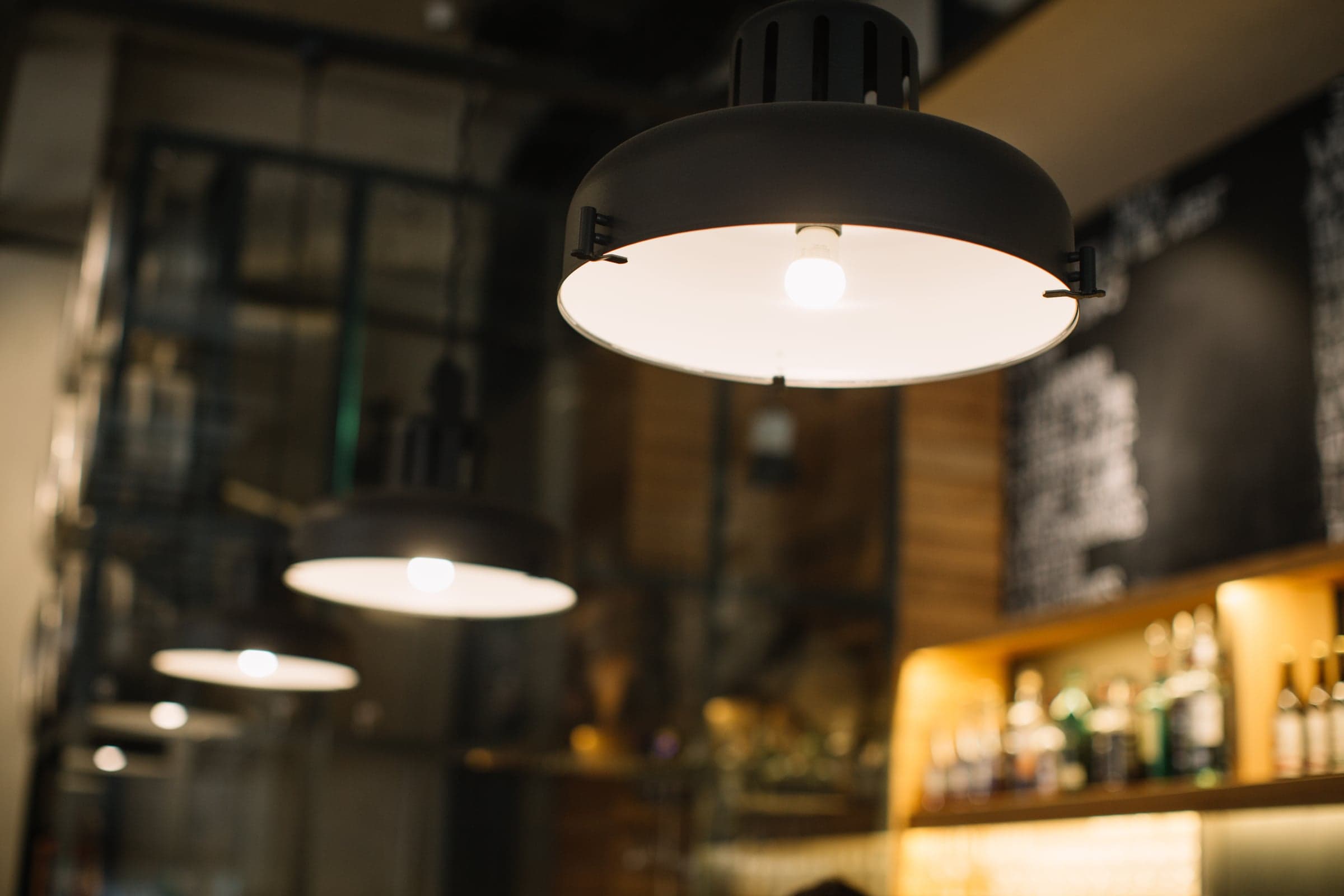 Warm pendant lighting glowing over a restaurant bar