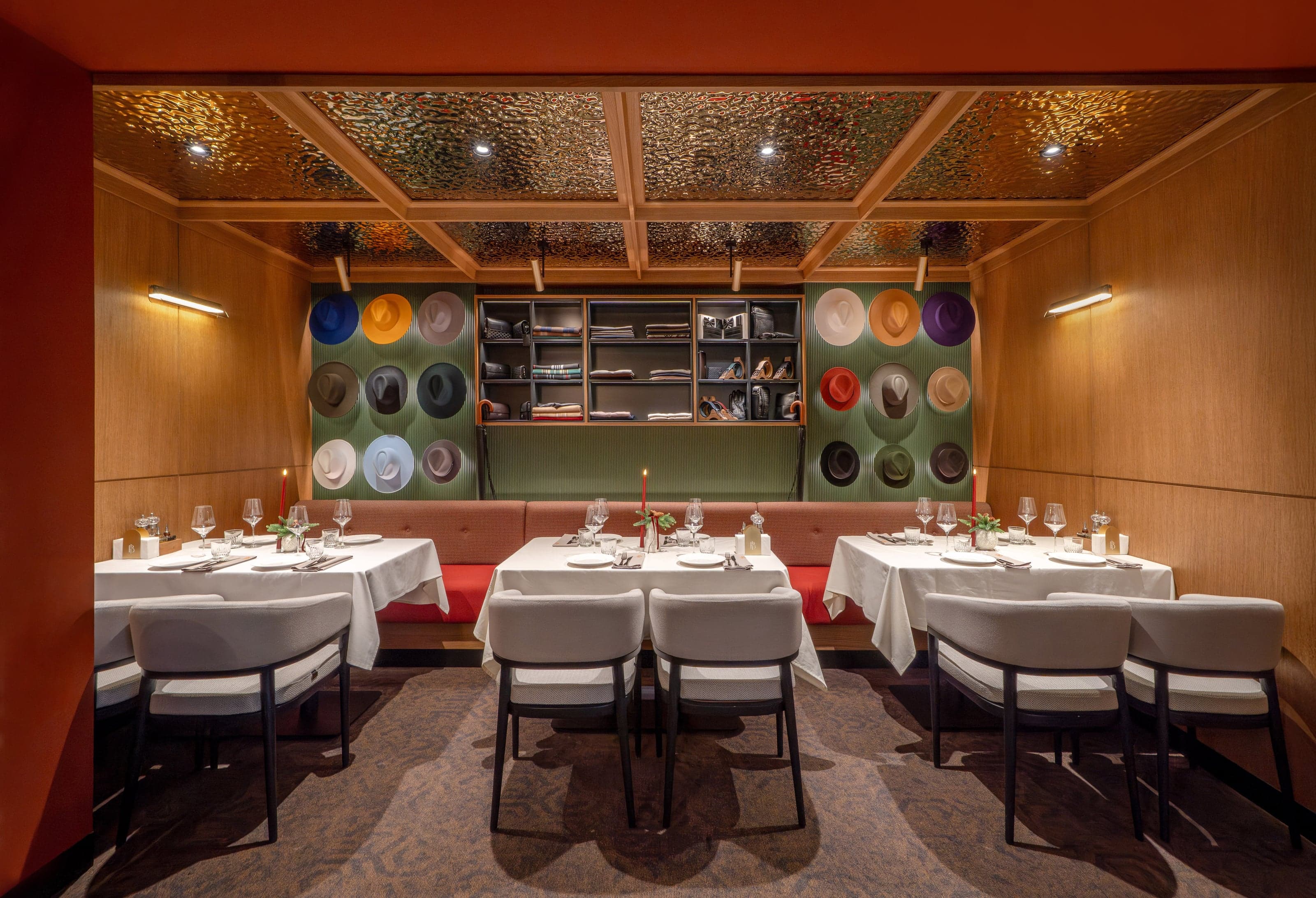 Bold Italic private dining room with a curated wall of fedora hats and accessories shelving