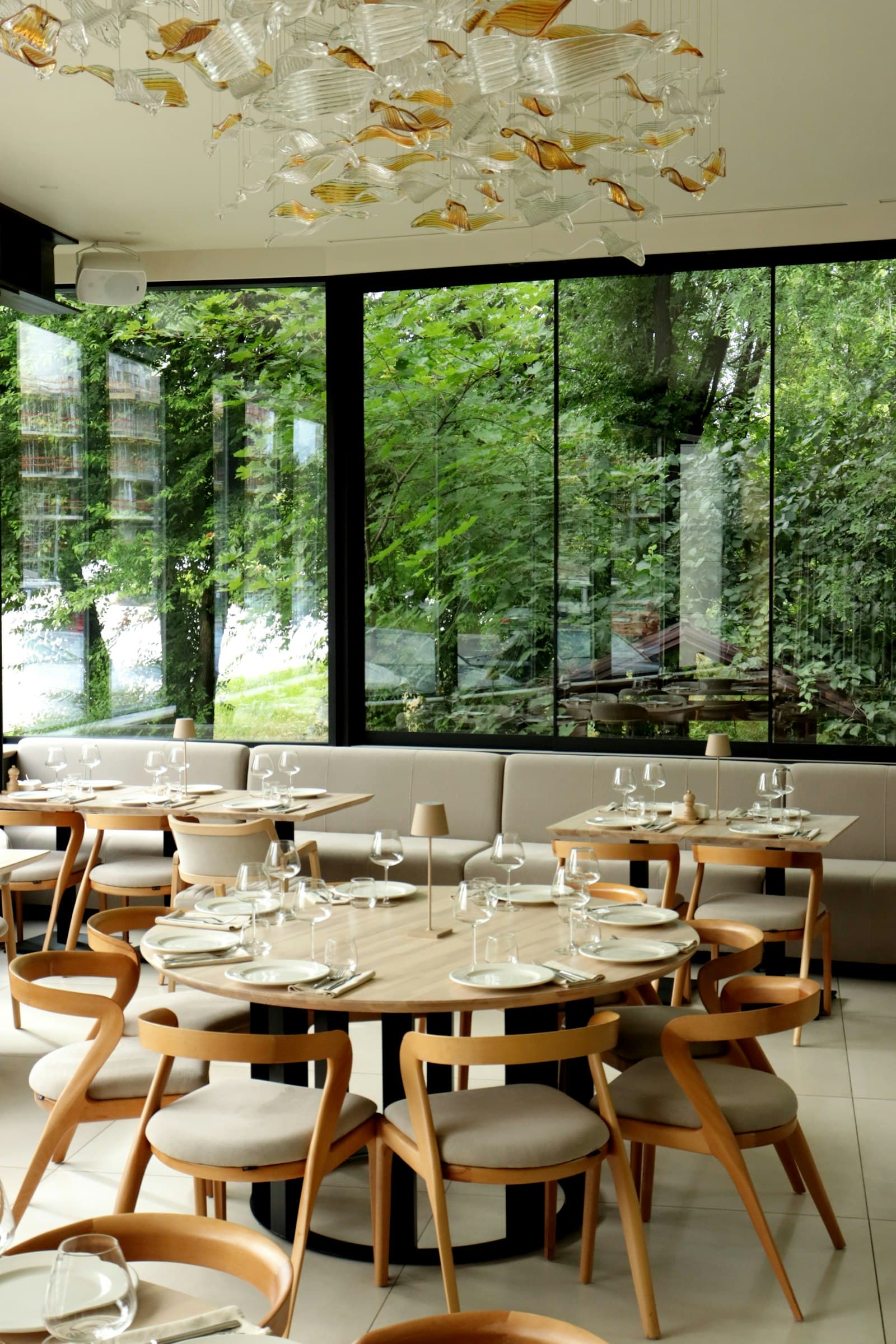 Orda restaurant dining room with glass wall overlooking greenery